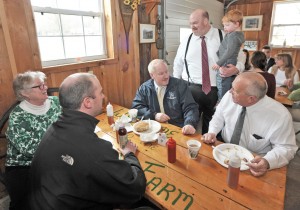 State Sen. Donald Humason Jr. standing rear, holds his son Quinn, while chatting with, Helene Florio, left, Michael Knapik, center, Peter Miller, foreground left, and State Rep. John Scibak, right, during a Legislative Breakfast sponsored by Humason. The gathering of local and state officials was staged at the Pomeroy Sugar House in Westfield Frida. (Photo by Frederick Gore)