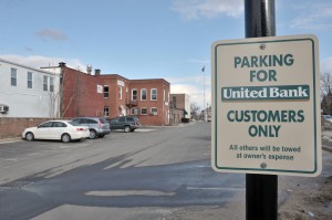 A sign at the entrance of the United Bank parking lot warns drivers that their car could be towed for non bank business. The Good Table Restaurant has a back door facing the parking lot. (Photo by Frederick Gore)