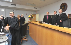 Judge Peter Agnes of the Massachusetts appeals court, sets the tiemr on his camera before hurrying to get in the picture with Judge David G. Sacks of theh probate court, Judge Philip A. Contant, first jsustice of Westfield District Court and Judge James Collins of the juvenile court after a celbration of Contant's 30th anniversary as a judge