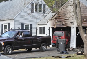 Contractors drag a Jeep Liberty SUV from a burned out garage after the vehicle was destroyed by a fire Friday afternoon. (Photo by Carl E. Hartdegen)