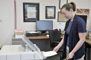 Jessica Menzone, an employee for the Town of Southwick, places a paper election ballot in a voting machine as part of a test for the upcoming local election and town meeting. The local Annual Election and Town Meeting will be on May 13, 2014 and May 20, 2014, respectively. (Photo by Frederick Gore) 