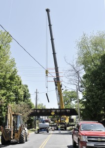 A large crane removes a structural support beam from the old railroad underpass on East Silver Street yesterday as part of the Columbia Greenway Project. (Photo by Frederick Gore)