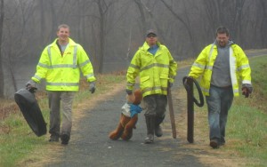 Lane Construction Co. volunteers haul out trash from the Westfield River dike, including an oversized teddy bear, during the April river cleanup. (Photo submitted)