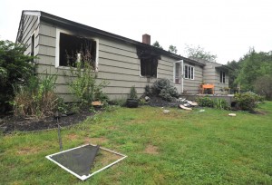 Gaping blackened windows of a house at 372 Montgomery Road look on to the back yard after a late Tuesday night fire. (Photo by Carl E. Hartdegen)