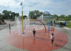 Three year olds Alex Bousquet-Powers and Ezequiel Vega run though the waters of the spray park at Chapman Playground where a community watch group has been organized to protect the playground and neighborhood. (Photo by Carl E. Hartdegen)