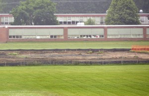Black plastic lines the perimeter of the former running track near the Powder Mill Middle School where contractors continue to demolish the 1/4-mile oval track. (Photo by Frederick Gore)