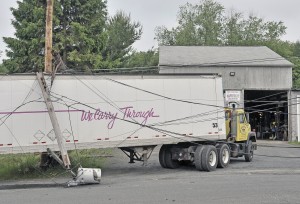 A trailer unit became tangled in power-lines after a reported brake failure at the Prifti Motors garage on Prifti Way in Southwick Tuesday morning. The unit reportedly rolled into a utility pole snapping it in two pieces which caused a power outage to a small strip mall where the Balance Hair Salon and Subway businesses are located. No injuries were reported. (Photo by Frederick Gore)