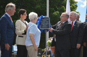 USPS Connecticut Valley District Manager David Mastroianni, Jr., presents the plaque which will be displayed in the Post Office building to Trant's wife, Mary. (Photo by Robby Veronesi)