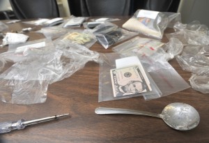 Evidence seized when city detectives executed a warrant on Collins Street Friday evening includes a spoon with cocaine residue and a small screwdriver apparently used as a spatula for fill tiny ziplock bags with narcotics. (Photo by Carl E. Hartdegen)
