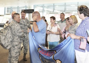 Ramon Diaz, left, receives a warm welcome from members of the Barnes 104th Fighter Wing during a ceremony at Bradley International Airport yesterday. Diaz has been depoyed overseas for the past six months with the United States Air Force. (Photo by Frederick Gore)