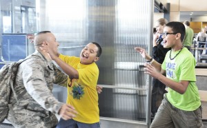 Ramon Diaz, of Westfield, left, runs to the waiting arms of his children Jake, 10, center, and Nick, 12, during a welcome home ceremony at Bradley International Airport yesterday. Also on hand was his wife Maria and friends and family members. Diaz was stationed overseas for six months. (Photo by Frederick Gore)