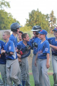 Andrew Pellegrini (right, in helmet) is mobbed by teammates after his game-winning hit gave Westfield American a thrilling 6-5 walk-off victory at Cross Street last night. Westfield scored two runs in the final inning after giving up a 4-1 lead. (Photo submitted by Kristen Koziol)