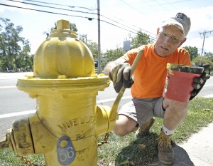 Rick Mannion, a seasonal employee for of the Southwick Department of Public Works, paints a fire hydrant along College Highway in Southwick yesterday. (Photo by Frederick Gore)