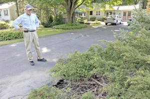 Mike Noble of Southwick checks the water damage, bottom right, to his yard and driveway after Wednesday's heavy rainfall. Noble said the damage was caused by the clearing of woodland above is property where a new solar farm is being built on College Highway near the Big Y.  (Photo by Frederick Gore)