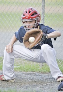 Westfield 14-Year-Old Babe Ruth catcher Nathan Boucher warms up the pitcher during yesterday's team practice at Bullens Field. (Photo by Frederick Gore)