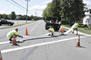 Employees from the Southwick Highway Department apply a reflective adhesive strip to mark the crosswalk at the Powder Mill School last August. The reflective strip replaced the conventional paint method of marking the crosswalk with paint. (WNG file photo)