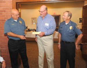 Robert Sorel, director of the city's auxiliary police force, accepts a $500 contribution from Mark Boardman, chair of the Westfield Rotary club's fireworks committee, in appreciation of the assistance provided by auxiliary officers at the Independence Day fireworks display in the city. Looking on is Auxiliary Lt. Don Humason Sr. (Photo courtesy The Rotary Club of Westfield)