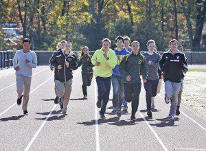 Members of the Southwick Tolland-Granville Regional High School Cross Country teams celebrate the opening of a new athletic track at the school with a ceremonial run yesterday. (Photo by Frederick Gore)