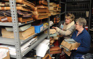 City Clerk Karen Fanion and her assistant, Donna Roy, sort some of the decaying city records in the clerk's vault which date back hundreds of years. Funds to preserve the records have been (Photo by Carl E. Hartdegen).