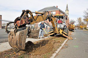 Joel Faira, a heavy equipment operator for the Westfield Department of Public Works, uses a backhoe to dig a hole on Mechanic Street where a tree will be planted as part of the Tree City USA program sponsored by the Arbor Day Foundation which recognize cities for their excellence in urban forestry management. Due to it's close proximity to a gas line much of the work had to be done by hand. (Photo by Frederick Gore)