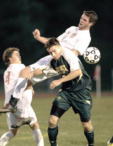 Southwick senior captain Jon Collins, foreground, battles a pair of Mt. Greylock defenders during Tuesday night's semifinal game in Northampton. (Photo by Frederick Gore)