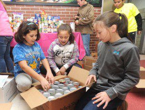 Sophia Roselli, Sophia Franco and Abby Menzel, fifth grades in Kristen Callini's class at Southampton Road School, pack up some of the more than 900 food items their class collected throughout the school during the past two weeks. The food was donated to the Westfield Food Pantry. (Photo by Carl E. Hartdegen)