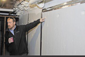 Tom Hartman, of Coldham & Hartman Architects, points out the new R-12 wall insulation panels mounted on the exterior walls of the basements of the Powdermill Village in Westfield where a $3 million energy conservation program was recently completed. (Photo by Frederick Gore)