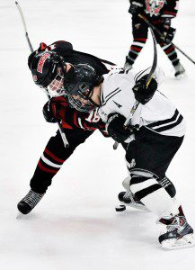 Westfield forward Joshua Adams, left, battles Longmeadow assistant captain Michael Tabb during the season opener at the Olympia Ice Arena Thursday night. The Bombers went on to win 9-1. (Photo by Frederick Gore)
