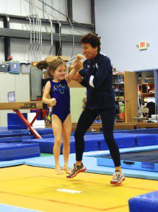 A gymnast jumps for Trampoline Development Coordinator Joy Umenhofer recently at Roots Gymnastics Center. (Submitted photo)