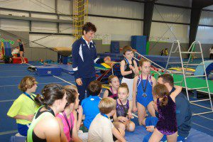 Members of the Roots trampoline and tumbling team listen to Trampoline Development Coordinator Joy Umenhofer during a recent practice. (Submitted photo)
