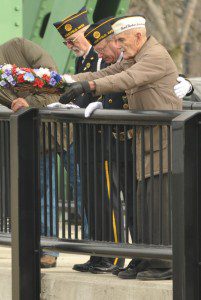 Westfield resident and Pearl Harbor survivor Robert Greenleaf, right, drops a ceremonial wreath into the Westfield River as part of last yarr's Pearl Harbor ceremony. Joining Greenleaf are, American Legion Post 124 Commander Edward Johnson, and Chaplin Paul Nimchick. The ceremony took place at the Great River Bridge. (File photo by chief photographer Frederick Gore)