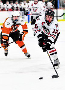Westfield's Chris Sullivan, right, moves the puck against Agawam during a 2014-15 regular season matchup at Amelia Park Ice Arena. (Photo by Frederick Gore)