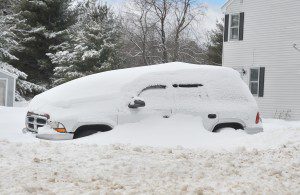 A car remains buried in the front lawn of a home on Point Grove Road in Southwick after a February 2014 snowstorm. (File photo by Frederick Gore)