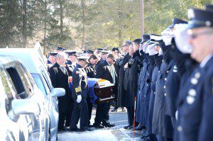 Massed firefighters salute as pallbearers carry Kevin Regan’s casket into Our Lady of the Blessed Sacrament Church at the start of his funeral services Saturday. (Photo by Carl E. Hartdegen)