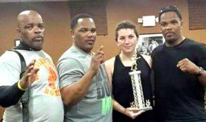 Taylor Smith, of Westfield (second from right) displays a trophy alongside her team of coaches from Whitley Brothers Boxing in Holyoke. (Submitted photo)