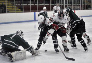 Westfield's Colin Burns, center, battles for the puck during Thursday night's tourney game against Minnechaug. (Photo by Frederick Gore)