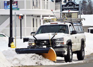 A plow operator drives along College Highway this morning clearing the snow from a nearby intersection. (Photo by Frederick Gore)