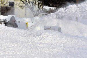 A man is barely visible behind a large pile of snow as he cleans his driveway this morning in Southwick. (Photo by Frederick Gore)