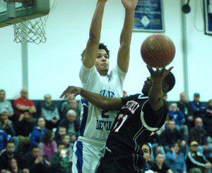 Westfield's Richie Barnett, right, attempts to flip a shot around the outstretched arms of Leominster's Derek Franks, left, in the Western Massachusetts Division 1 boys' basketball quarterfinals Thursday night. (Photo by Chris Putz)