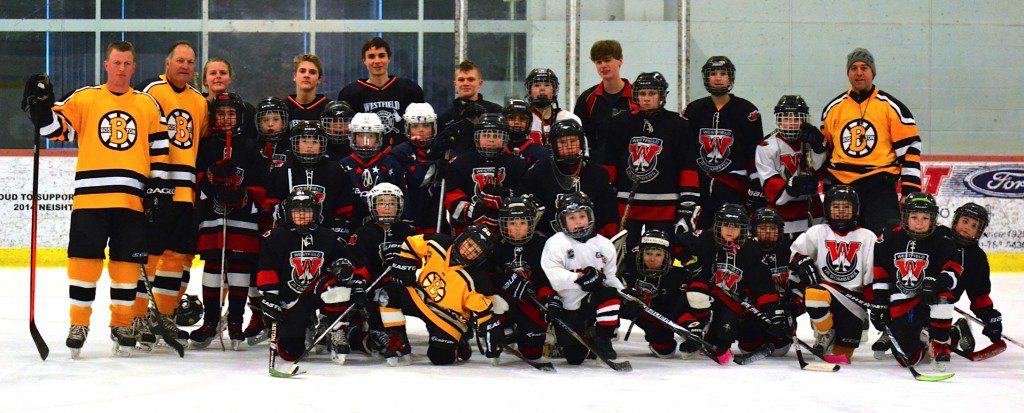 A few members of the Black and Gold Legends pose for a team photo alongside several area youth hockey players following a skills clinic Sunday.