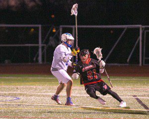 Westfield's Sam Scarfo makes a move against a West Side long pole defender, and makes a drive to the net. (Photo by Liam Sheehan)