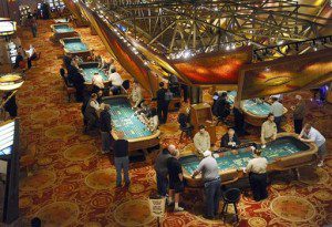 In this Sept. 18, 2013 file photo, patrons play craps at tables at Mohegan Sun in Uncasville, Conn. Lawmakers from Connecticut to Maine have introduced bills to expand their residents’ gambling options. Mohegan Sun and other gambling houses are making moves to shore up business as MGM, Wynn and other new rivals prepare to enter the market in Massachusetts. (AP Photo/Jessica Hill, File)