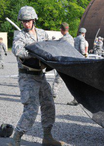 An Airman from the 104th Emergency Management Flight, Barnes Air National Guard Base, carries a fly cover for a Triple-S tent, May 12, at Ramstein Air Base, Germany. He is building a tent with other active duty, guard and reserve members in preparation for Exercise Silver Flag. (U.S. Air National Guard photo by Tech. Sgt. Melanie J. Casineau/Released)