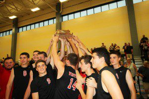 Members of the Westfield Bombers boys'  volleyball team hoist the championship trophy.