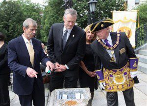 From left, Secretary of the Commonweath William Francis Galvin, Massachusetts Gov. Charlie Baker, Lt Gov Karyn Polito and Grand Master of the Grand Lodge of Masons Harvey Waugh peek into the crevice that will hold the time capsule dating to 1795 when it was revealed during a ceremony at the Statehouse steps, Wednesday, in Boston. A set of 2015 U.S. mint coins and a silver plaque were added to its contents for a future generation to discover. (Joanne Rathe/The Boston Globe via AP, Pool)