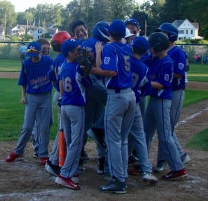 Westfield American's Jake LaBombard jumps into the arms of teammates, who swarm him at home plate after clubbing a home run. (Photo by Chris Putz)