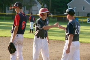 Westfield Babe Ruth Baseball 14-Year-Old All-Stars' Cam Parent, center, fist bumps coach Jim Hagan after recording the first hit for the home team Tuesday night against Pittsfield. (Photo by Chris Putz)