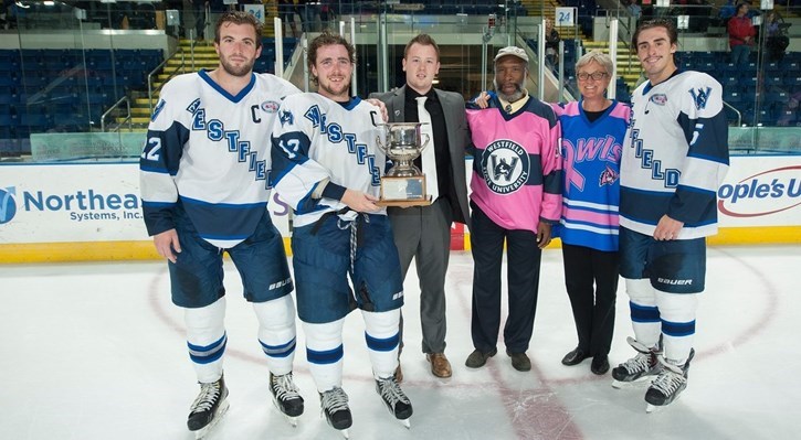 Westfield State's captains accept the Falcon Cup. From left; Kyllian Kirkwood, Dalton Jay, David Jones from the Springfield Falcons, Westfield State vice president Dr. Carlton Pickron, Westfield State Interim President Dr. Elizabeth Preston and Jackson Leef. (Courtesy of Westfield State Sports)