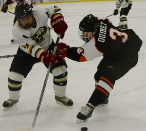 St. Mary forward Tanner Hart, left, muscles the puck past South Hadley’s Trevor Ouimet, right. (Photo by Chris Putz)