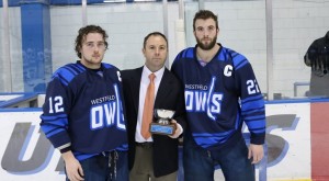 Westfield State captains Dalton Jay and Kyllian Kirkwood are presented with the runner-up trophy at the 51st Annual Codfish bowl tournament by UMass Boston head coach Peter Belisle. (Photo courtesy UMB)